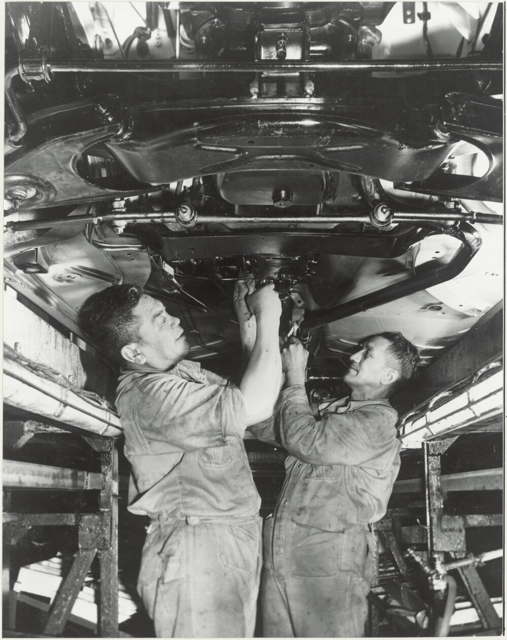 General Motors: two workers underneath a car