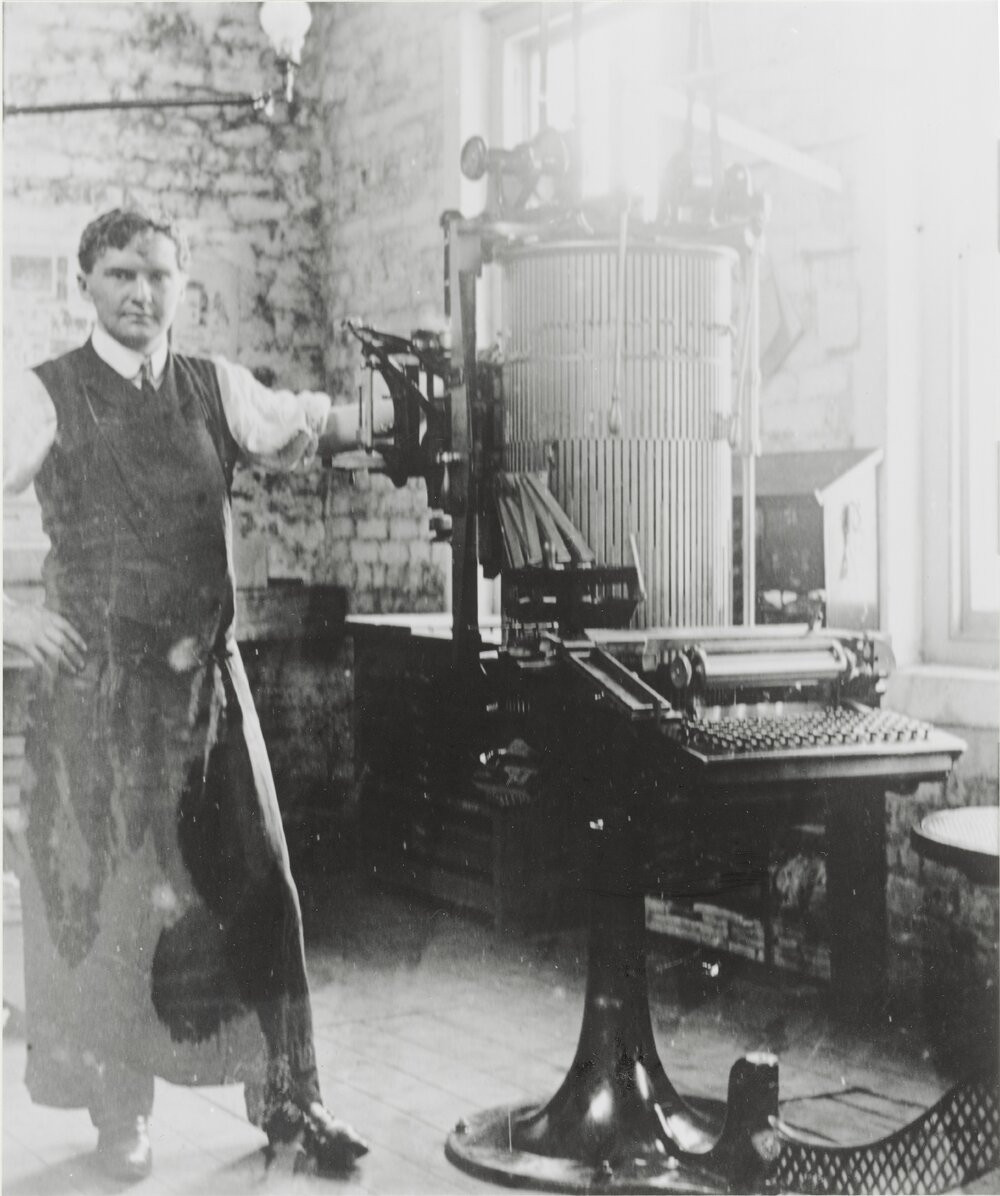 Herbert Robinson, apprentice with the "Hutt & Petone Chronicle", standing beside his typesetting machine at the newspaper premises, 46 Sydney Street, Petone in 1905 or 1906.