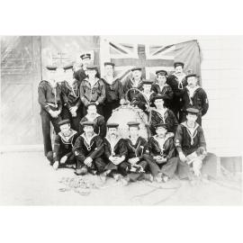 Group of Petone navals with flags on the wall behind